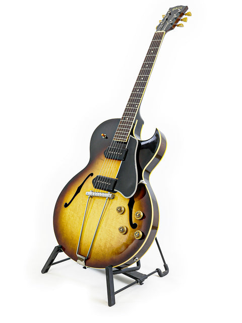 A beautifully crafted 1959 Gibson ES-225TD guitar on a stand, representing timeless elegance in vintage musical instruments.