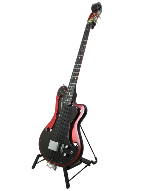 A black and red electric guitar resting on a stand, emphasizing its retro style and vibrant color scheme.

