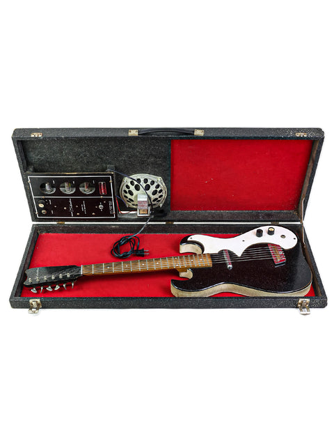A black and white electric guitar, the Harmony Silvertone 1448, housed in a case, featuring 'Amp-in-Case' from the 1960s.
