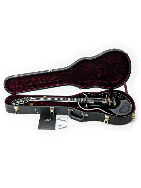 A black guitar case showcasing a Gibson Custom Shop Les Paul Custom guitar from 2010 nestled inside.