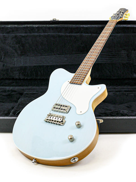 A blue electric guitar, the Koll Troubadour from 2013, resting in a sturdy case, ready for transport.
