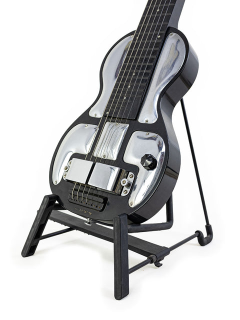 A classic 1930s Rickenbacher Electro B-6 Lap Steel guitar displayed on a metal stand with a white backdrop.