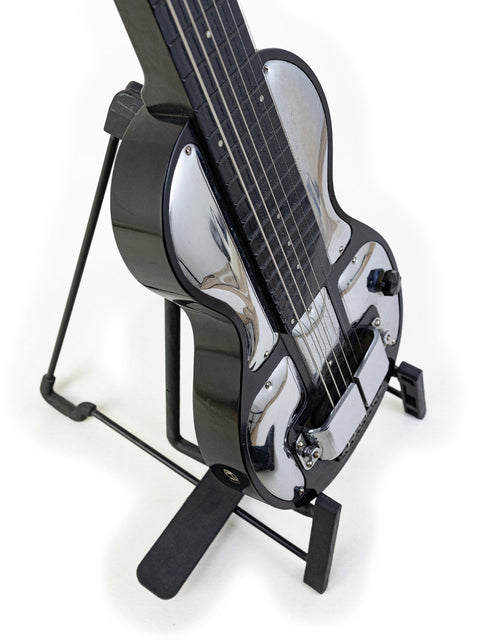 A classic 1930s black Rickenbacher Electro B-6 lap steel guitar displayed on a sturdy metal stand.
