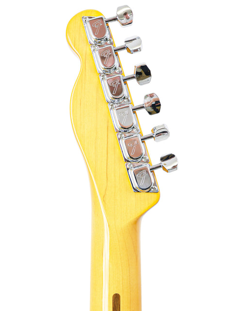 A close-up shot of a guitar head, highlighting the bright yellow body of the Txxx Custom Thinline '72 Partscaster made in 2022.