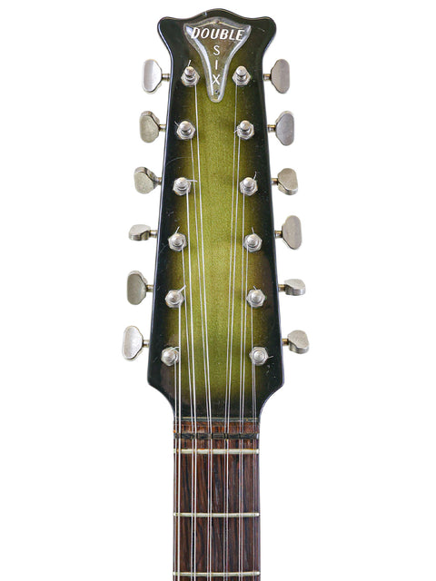 A close-up view of a 1964 Burns Double Six 12-string guitar, highlighting its vibrant green headstock.
