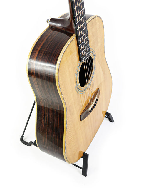 A guitar displayed on a stand with a plain white background, showcasing the Jim Williams WD-40 branding from Australia, 2005.
