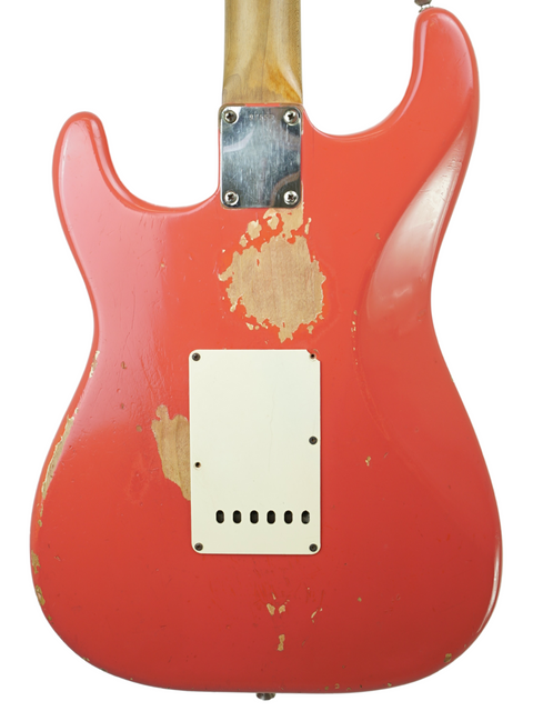 A red 1963 Fender Stratocaster guitar, distinguished by its wooden body and elegant white pickguard.