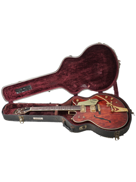A red 1967 Gretsch 6122 guitar rests inside a vintage case, exemplifying classic craftsmanship and design.