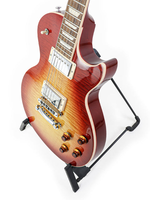 A striking Gibson Les Paul Standard guitar with a vibrant red sunburst finish, beautifully showcased on a stand for display.