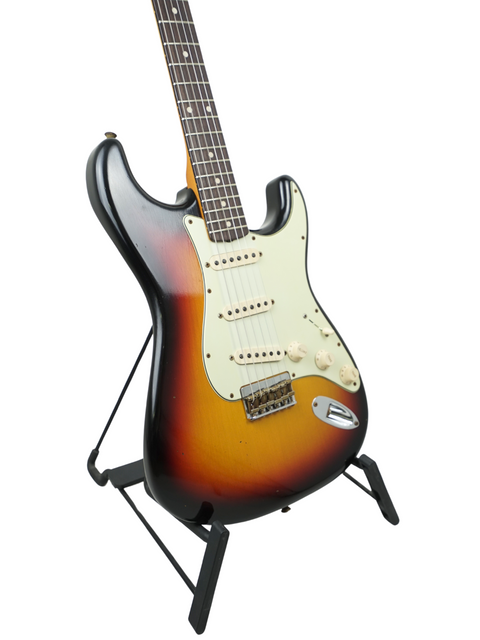  A striking sunburst Fender Custom Shop '60 Stratocaster Hardtail on a stand, emphasizing its classic appeal and quality.