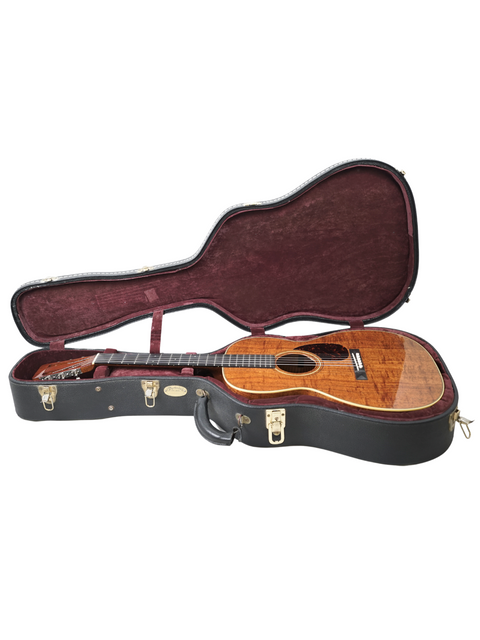 A stylish black guitar case encasing a Martin 000-28K, highlighting its wooden body and classic craftsmanship from 2014.