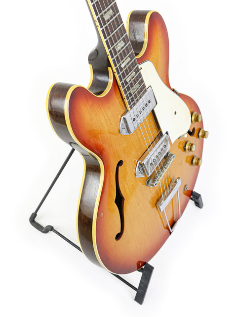 A vintage 1965 Epiphone Casino guitar elegantly displayed on a stand, showcasing its classic design and craftsmanship.