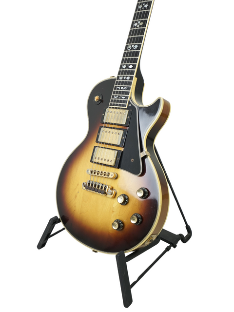 A vintage Gibson Les Paul Artisan guitar from 1978 resting on a stand, set against a dark background.