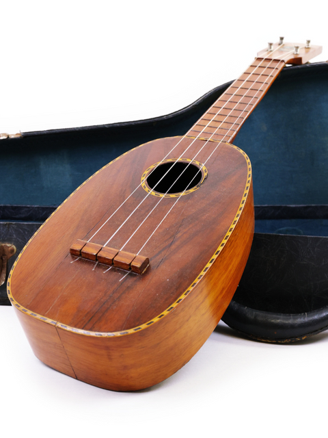 A vintage Kamaka Pineapple Style #3 ukulele, circa 1928, positioned in its case on a white backdrop.