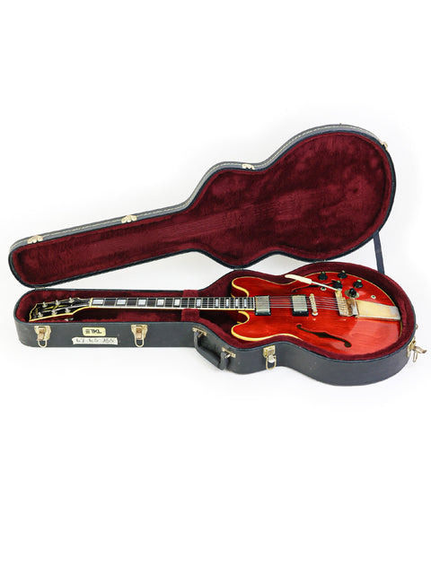A vintage red Gibson ES-355 Stereo guitar from 1967, resting in its case on a pristine white surface.