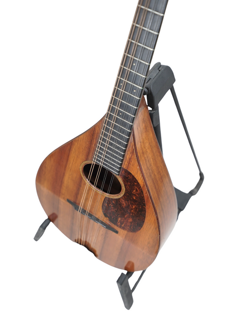 A wooden guitar, the vintage Martin AK Mandolin from 1924, elegantly perched on a stand, ready to play.