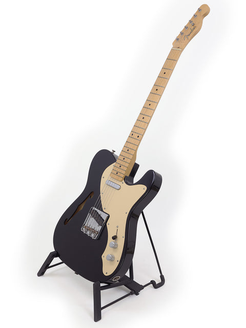  Black Fender Custom Shop Telecaster Thinline electric guitar from 2005, resting on a stand, highlighting its classic style.
