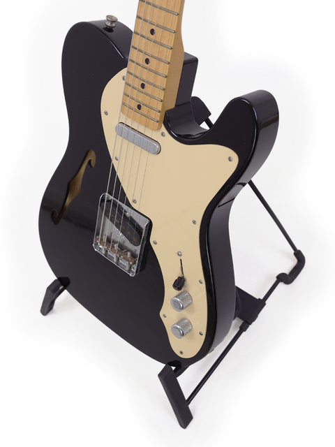 Black Fender Custom Shop Telecaster Thinline guitar on a stand against a clean white background.