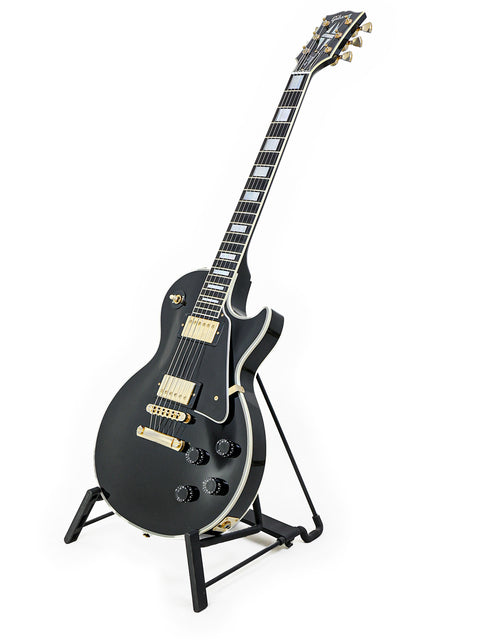 Black Gibson Custom Shop Les Paul Custom electric guitar on a stand, showcasing its sleek design and craftsmanship.