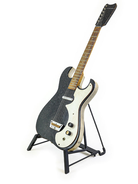 Black Harmony Silvertone 1448 guitar on a stand, featuring 'Amp-in-Case', displayed on a white backdrop.