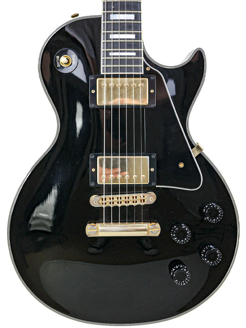  Black electric guitar with a gold pickguard, a Gibson Custom Shop Les Paul Custom from the USA, 2010 model.