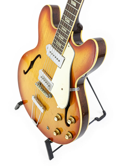 Brown-bodied Vintage Epiphone Casino guitar from 1965 set against a stark white background.