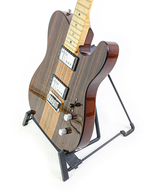 Brown electric guitar on stand against a white background.