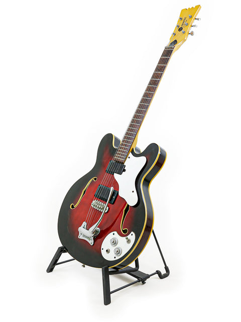 Classic 1967 Mosrite Celebrity III guitar resting on a stand, highlighted by a simple white background for a timeless look.