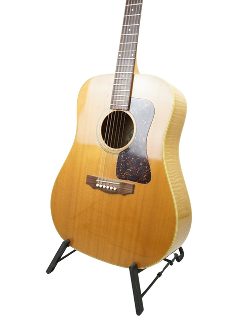 Classic Guild D030A07 Dreadnought guitar from 1987 elegantly positioned on a stand, ideal for any music lover's collection.