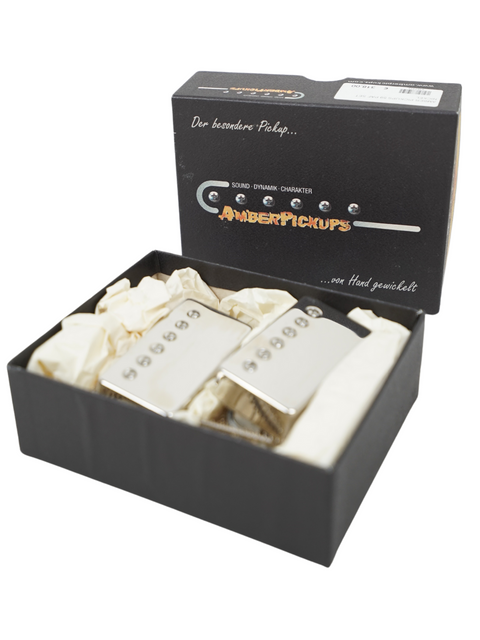 Close-up of Amber Spirit of '59 humbuckers box with the pickups displayed, highlighting their sleek metal finish and handwound quality.

