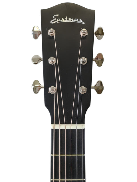 Close-up of a guitar headstock with the "Eastman" logo, showing tuning pegs and strings.