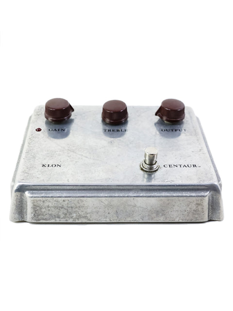 Close-up of a silver metal effects pedal with four adjustable knobs, identified as the 1999 Klon Centaur "Non-Horsie."