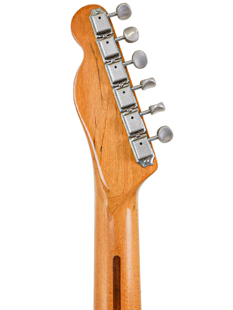 Close-up of a vintage Fender AVRI ‘52 Telecaster, emphasizing the warm tones of its wooden body and classic craftsmanship.
