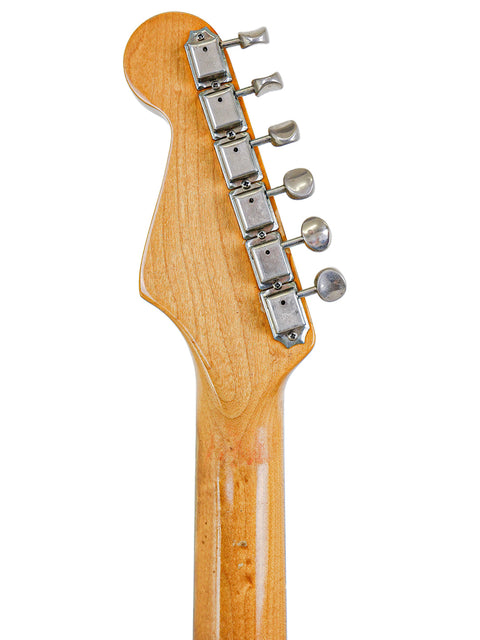 Close-up of a vintage Fender AVRI ‘62 Stratocaster guitar head, showcasing its wooden body and timeless design from 1982.