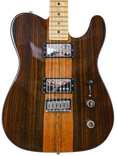 Close-up of a wood grain electric guitar with two pickups and control knobs.