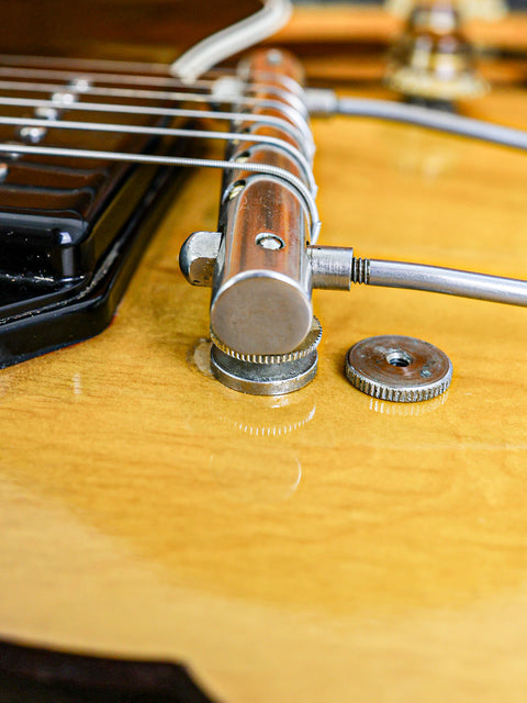 Close-up shot of a 1959 Gibson ES-225TD guitar, highlighting the elegant metal cap and vintage craftsmanship.