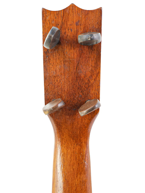 Detailed view of a 1920s Kumalae ukulele headstock, highlighting the rich wood texture and classic design from Hawaii.