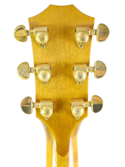 Detailed view of a 2003 Taylor 610CE guitar headstock, showcasing four knobs for tuning and sound control.