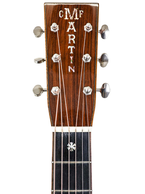 Detailed view of the headstock of a Martin acoustic guitar, highlighting the logo and craftsmanship of the 2019 Custom Shop model.