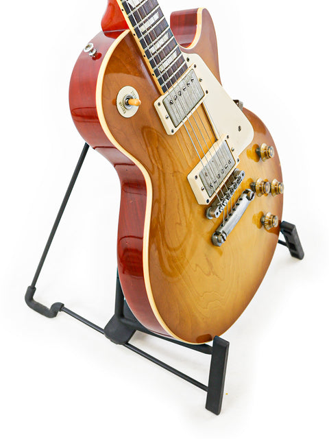 Elegant Gibson Custom Shop LPR-8 1958 Les Paul Reissue guitar resting on a stand, set against a white background.