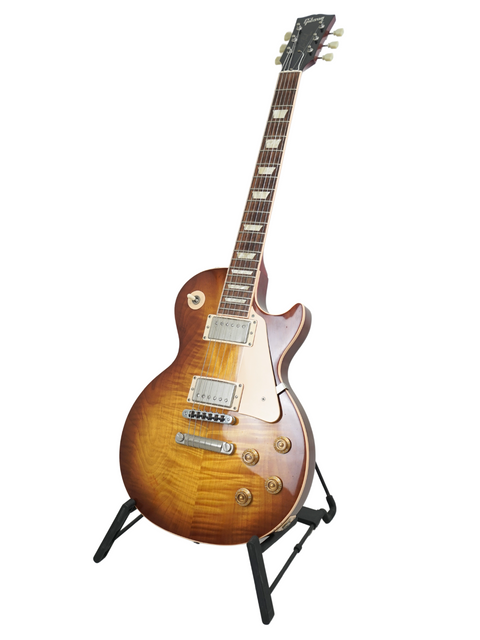 Elegant Gibson Les Paul Standard 60s guitar resting on a stand, highlighted by a minimalist white background.