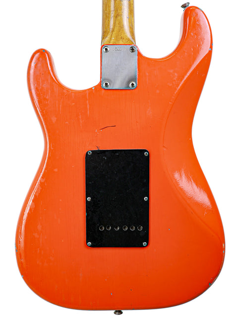 Eye-catching orange 1963 Fender L-Series Stratocaster guitar with a black pickguard, a true vintage gem for musicians.