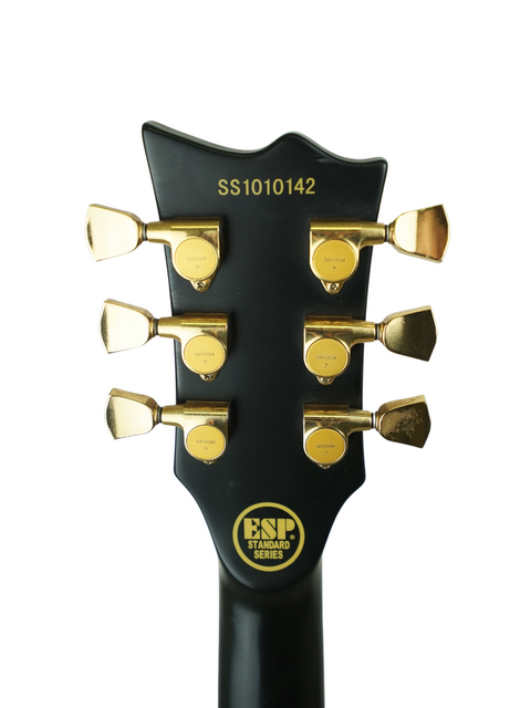 Headstock of a black guitar with gold tuning pegs and an "ESP Standard Series" logo.