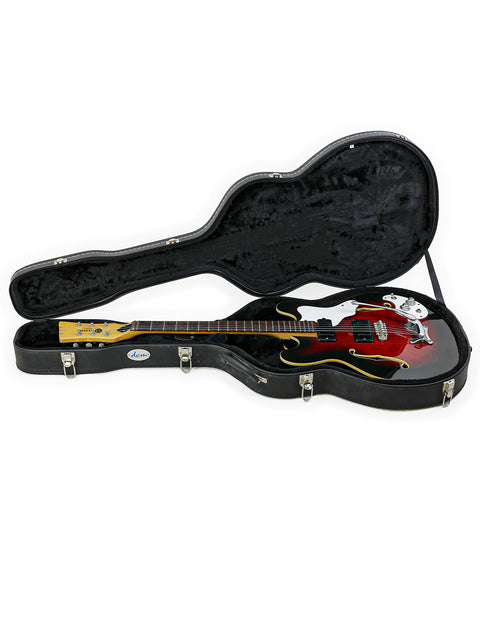 Inside a guitar case, a red and black vintage Mosrite Celebrity III from 1967 awaits its next performance.