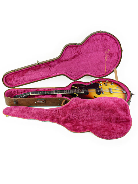 Inside a vintage Gibson ES-330TD case from 1964, a vibrant pink lining adds a pop of color to this classic piece.