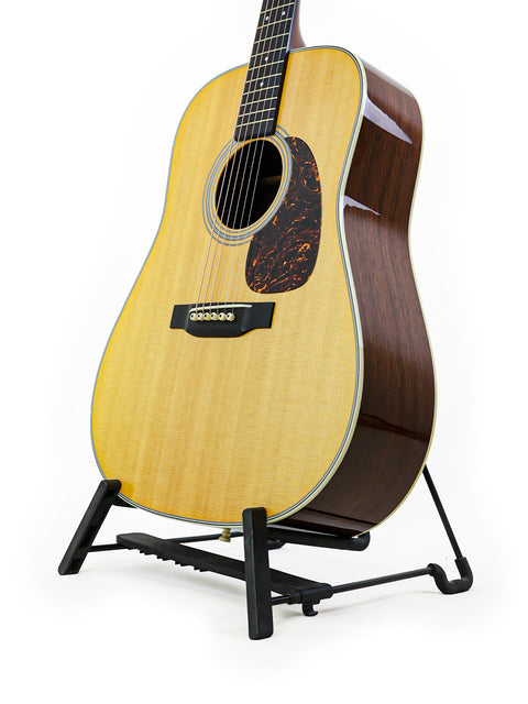 A Martin D-28 CFM IV guitar on a stand against a clean white background, showcasing its limited edition design.