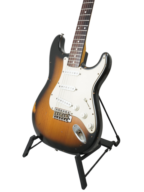 Nash S63 Stratocaster Relic guitar on a stand against a clean white background, showcasing its vintage design.