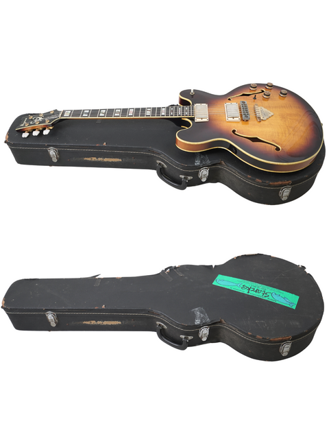 Open cases reveal two guitars, including a Vintage Ibanez Artist 2630 from Japan, 1979, on a white surface.
