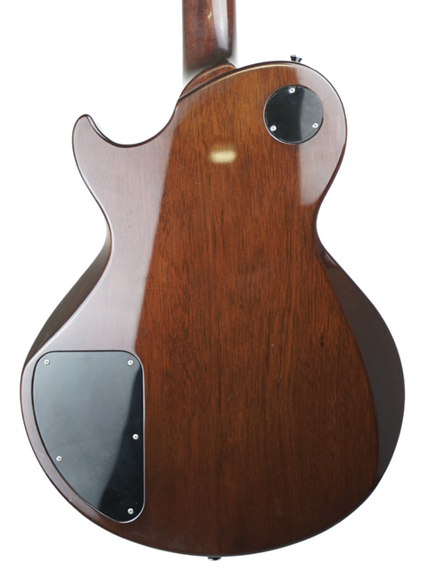 Rear view of a brown electric guitar body with black pickguard plates.