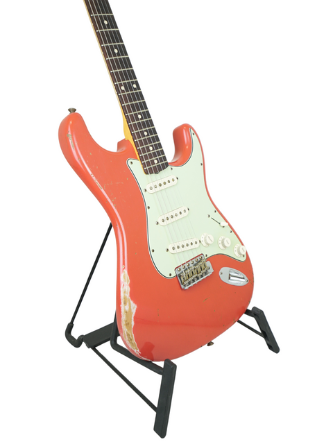 Red Fender Kyle McMillin Masterbuilt 1960 Stratocaster Relic guitar positioned on a stand with a plain white background.
